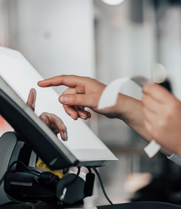 A shop employee entering a coupon value on a POS device