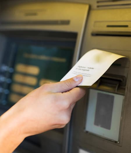 Woman taking the deposit slip at an ATM