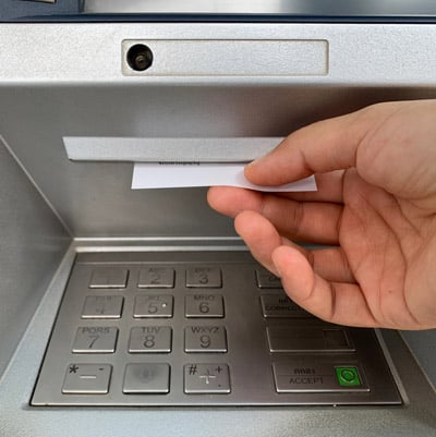 Man taking a deposit slip from an ATM