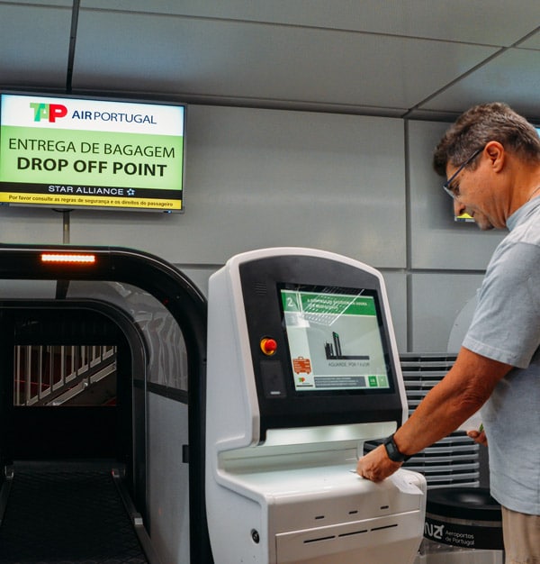 Man printing a Baggge tag at a self-service kiosk