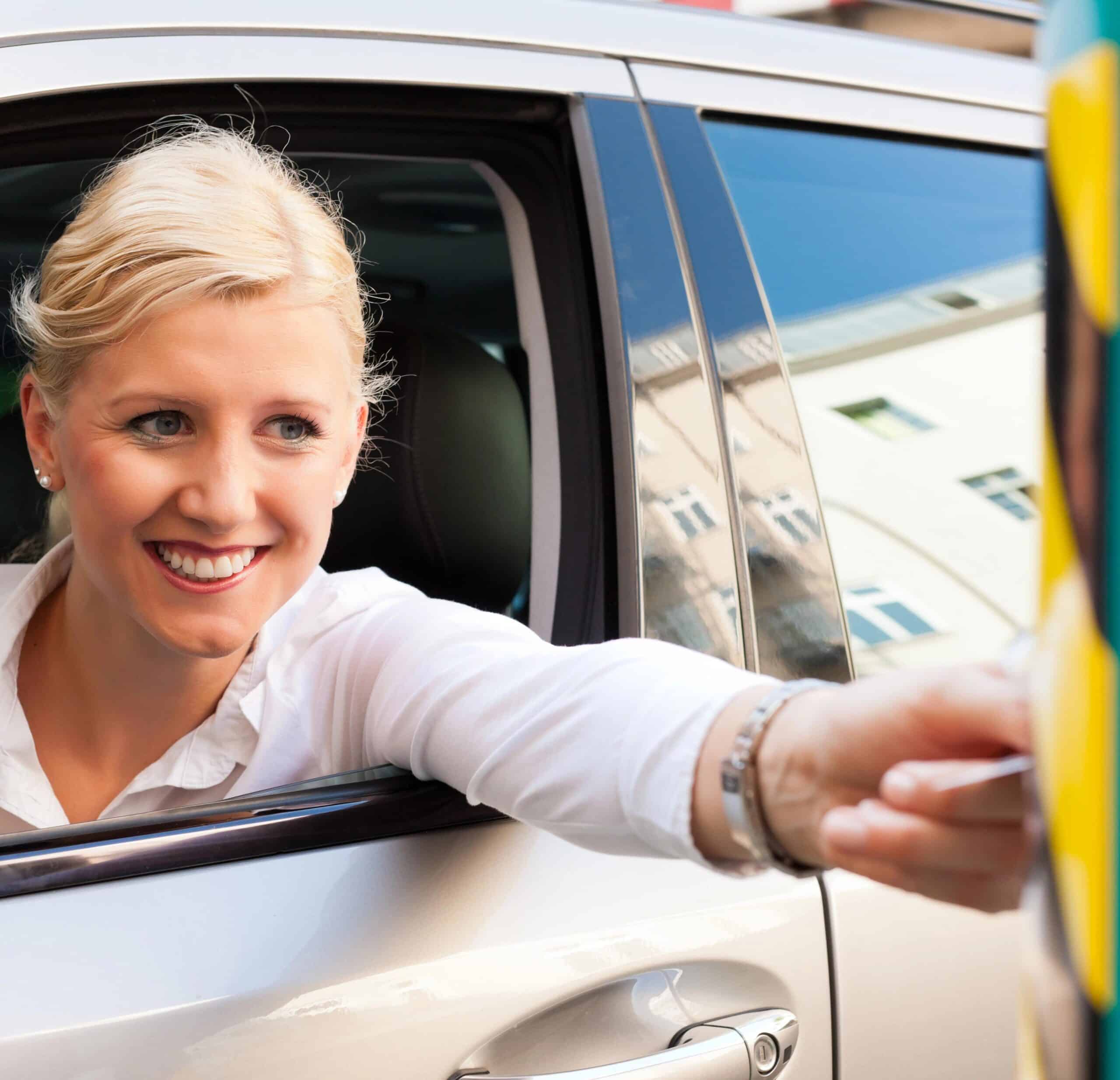 Woman inserting ticket at parking barrier