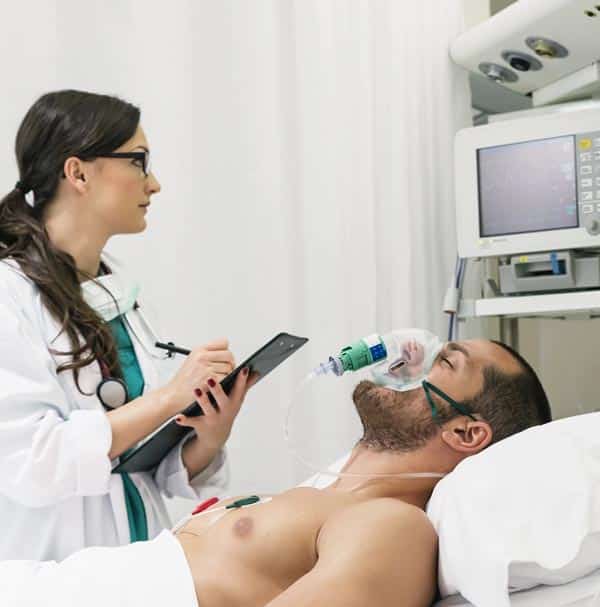 Patient in an hospital, with a doctor checking monitoring devices