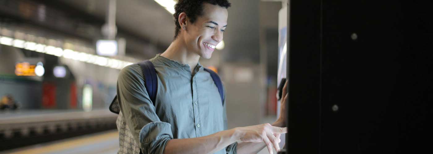 Young man using a vending machine in a subway station